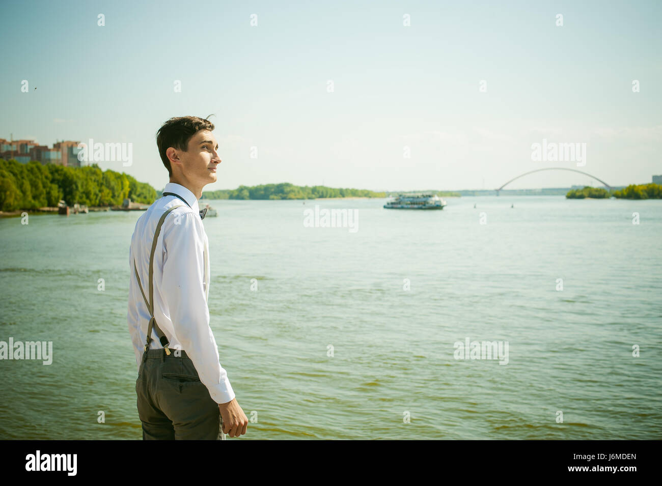 Jeune homme filiforme, élégamment habillé élégamment en chemise blanche,  pantalon gris avec bretelles et dentelle. À la suite, à l'eau de la rivière  Bridge et s Photo Stock - Alamy