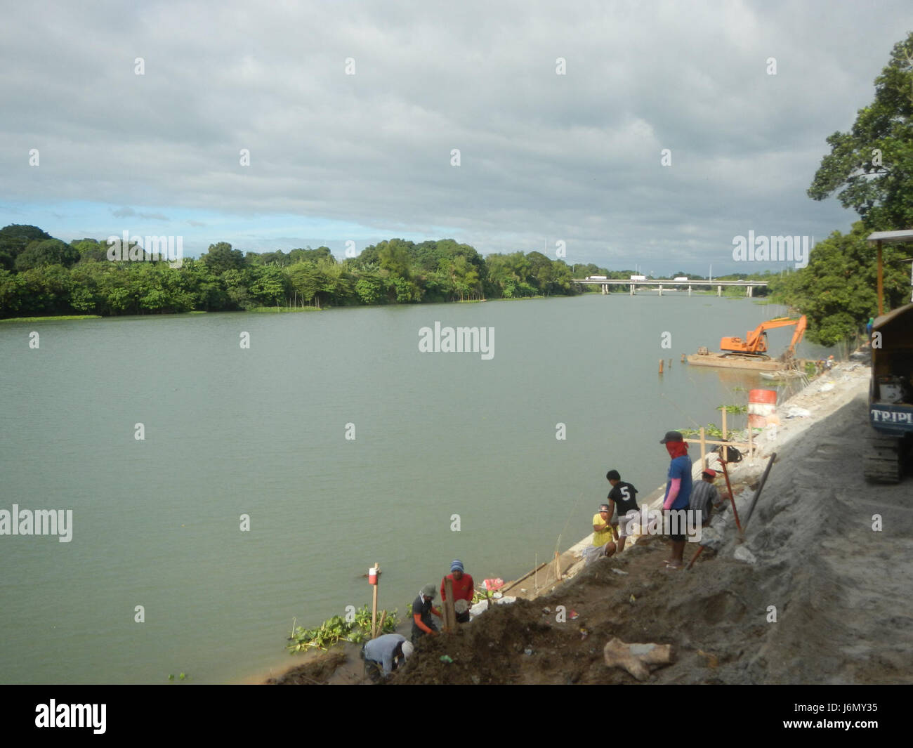 La construction de riprap le long des berges de Pulilan à Plaridel, Bulacan, vise à protéger les berges de l'érosion et à améliorer la durabilité des infrastructures routières. Le projet renforce la stabilité de la région de Sipat Dampol, en assurant des routes plus sûres pour la circulation locale et en prévenant les dommages causés par les inondations et les écoulements d’eau. Banque D'Images