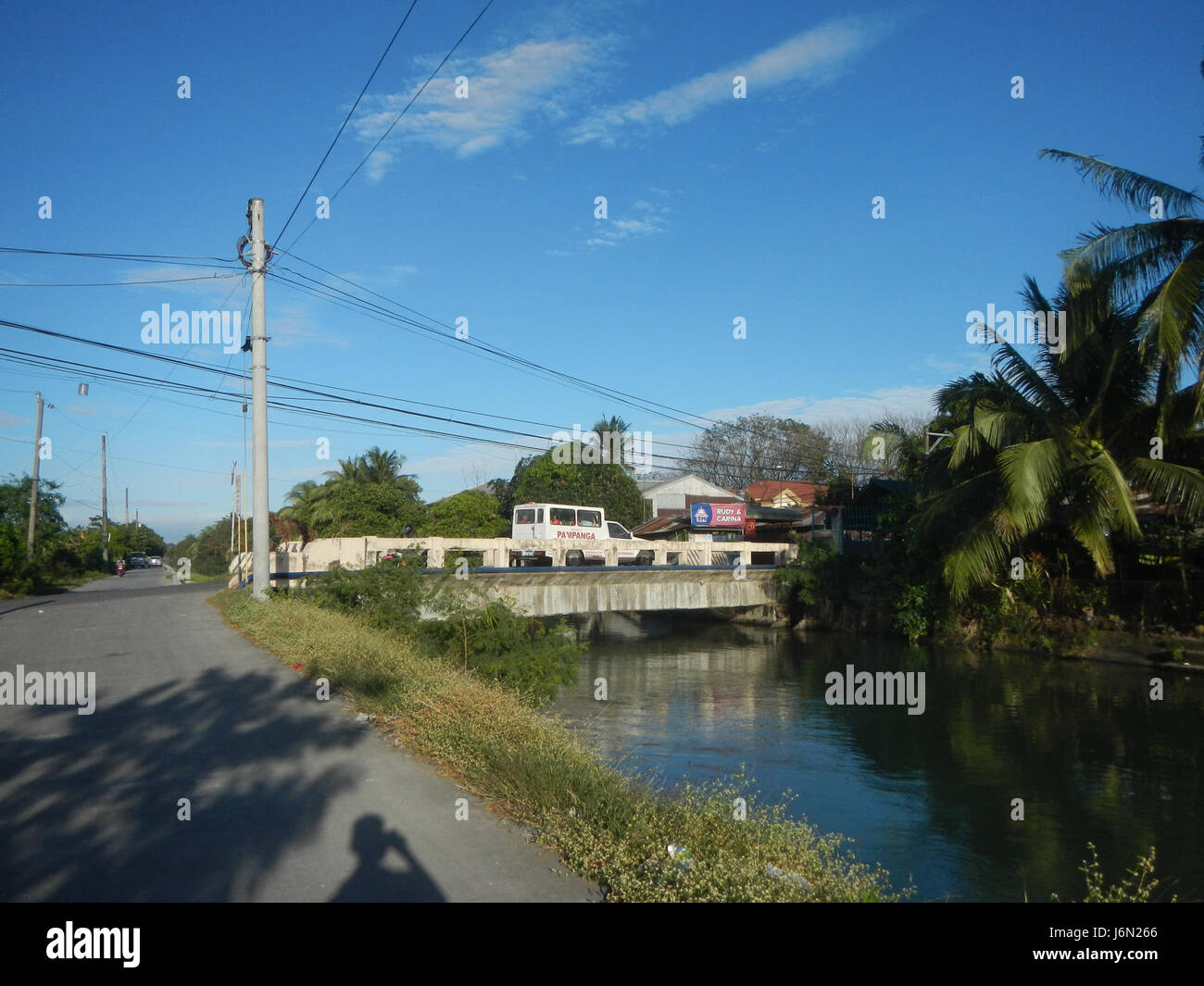 À Sabang, Baliuag, Bulacan, ce site présente un paysage de rizières, de prairies et d'arbres, avec des maisons et des systèmes d'irrigation, reliés par des ponts routiers. Il met en lumière les infrastructures agricoles de la région. Banque D'Images