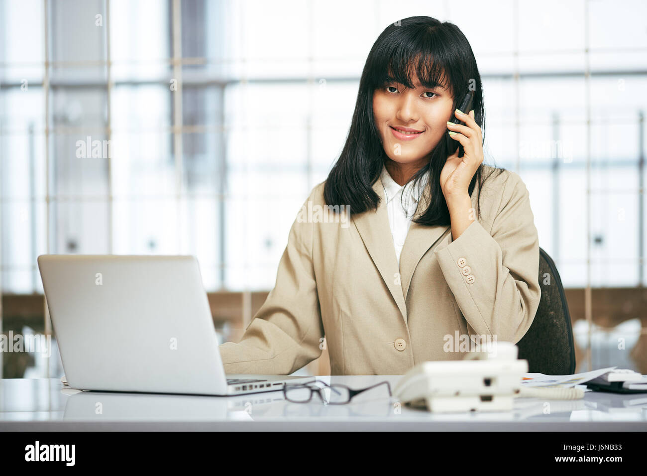 Close up of businesswoman talking on the phone while using computer in office Banque D'Images