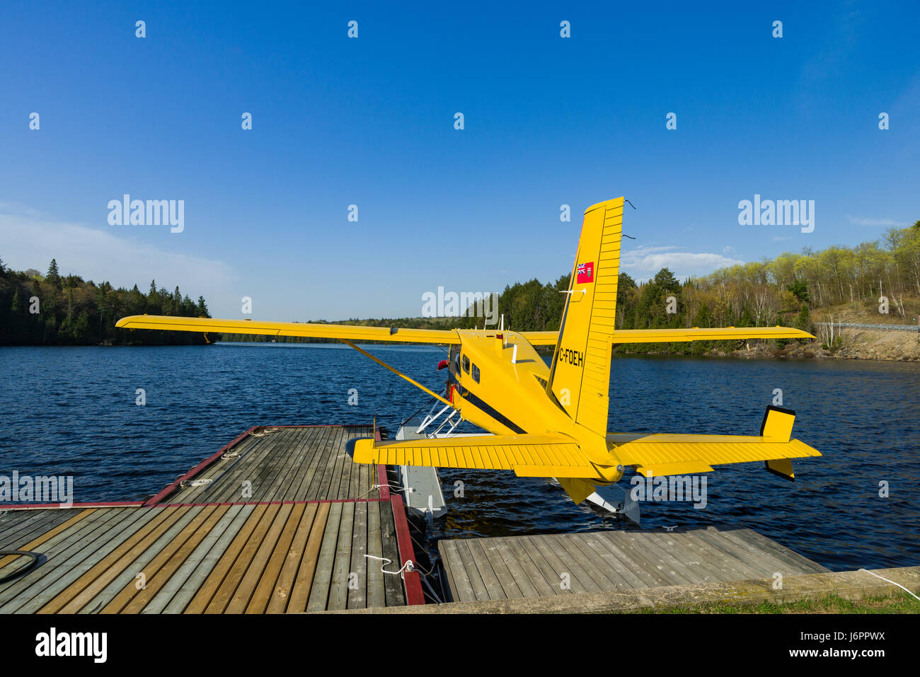 Un hydravion jaune amarré à une jetée en bois dans un petit port, un jour ensoleillé, Algonquin Provincial Park, Ontario, Canada Banque D'Images