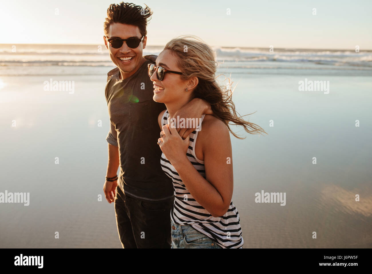 Portrait of young couple en train de marcher sur la mer. Homme et femme sur la plage de vacances pendant l'été. Banque D'Images