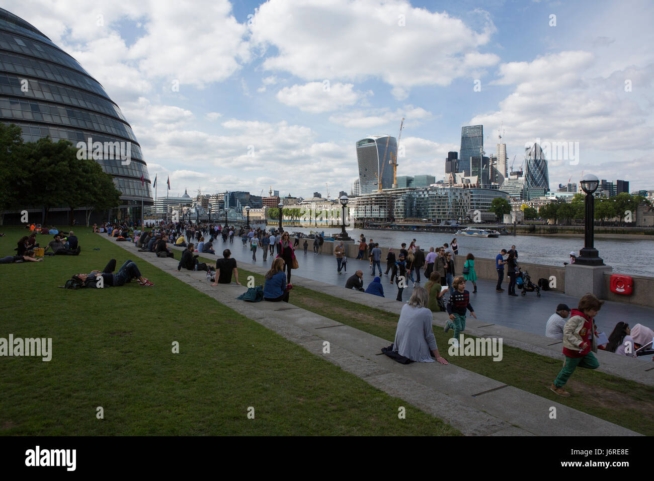 Les touristes se détendre dans les champs de potiers parc en face de Tower Bridge, Londres, Angleterre, Royaume-Uni Banque D'Images