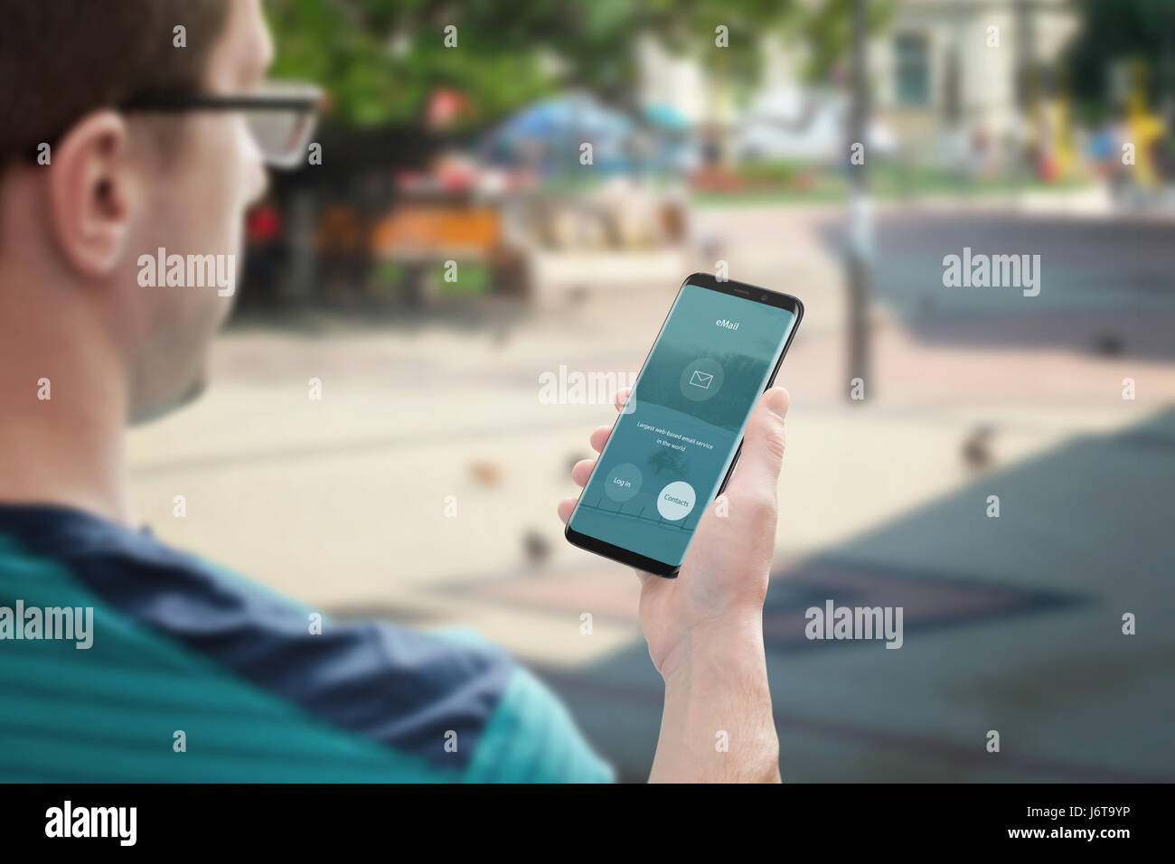 L'envoi d'e-mail avec votre téléphone mobile. Guy utilisez l'e-mail à contacter les membres de l'app. Banque D'Images