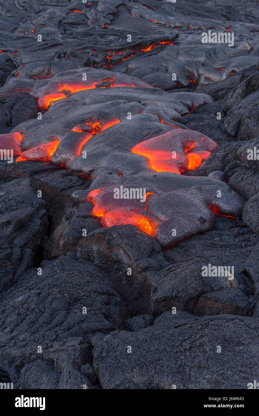L'écoulement de surface de la lave s'échappe par les coins et recoins de la lave séchée pendant une éruption du volcan Kilauea. Banque D'Images