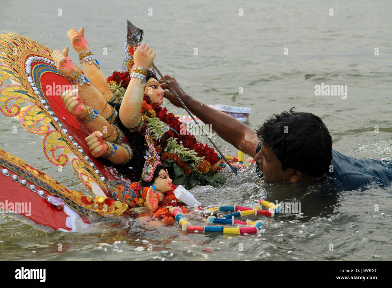 Un dévot hindou une idole plonge de la Déesse Durga dans la rivière Buriganga. Dhaka, Bangladesh. Banque D'Images