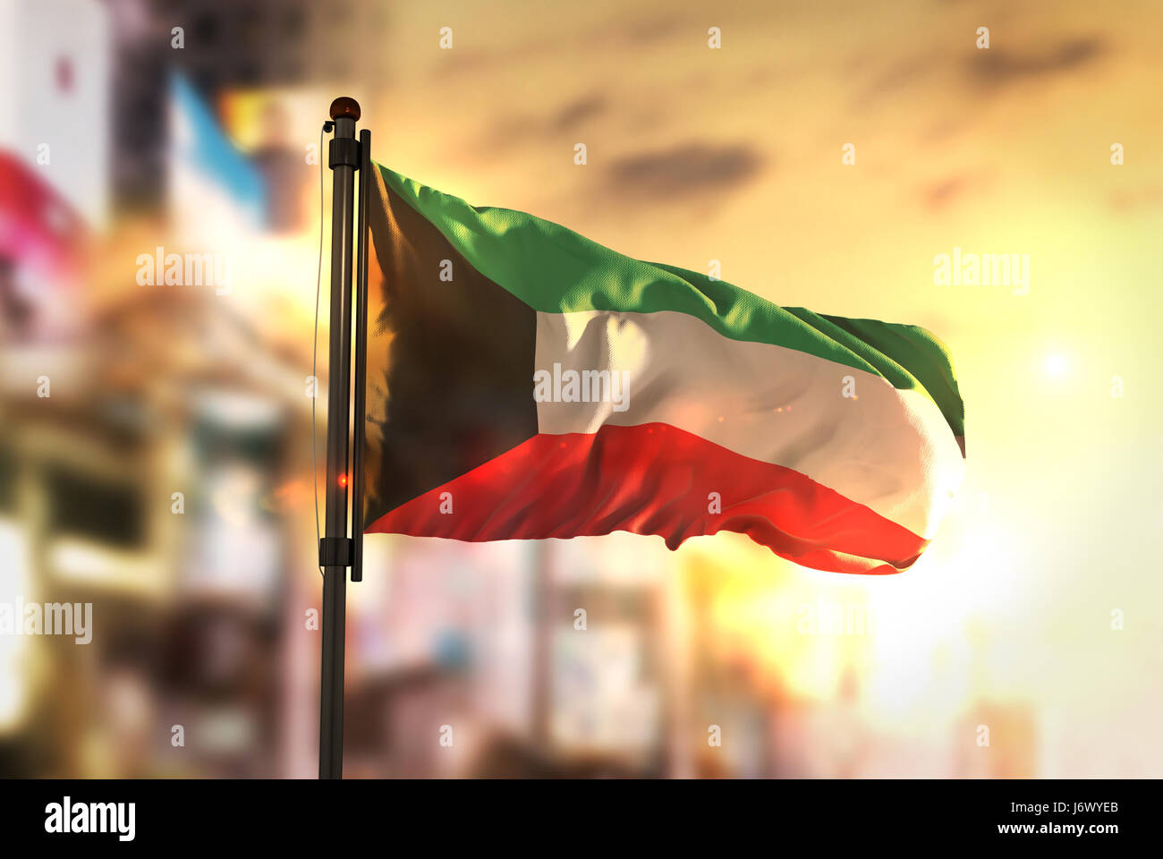 Drapeau Koweït contre ville fond flou rétroéclairage au lever du soleil Banque D'Images