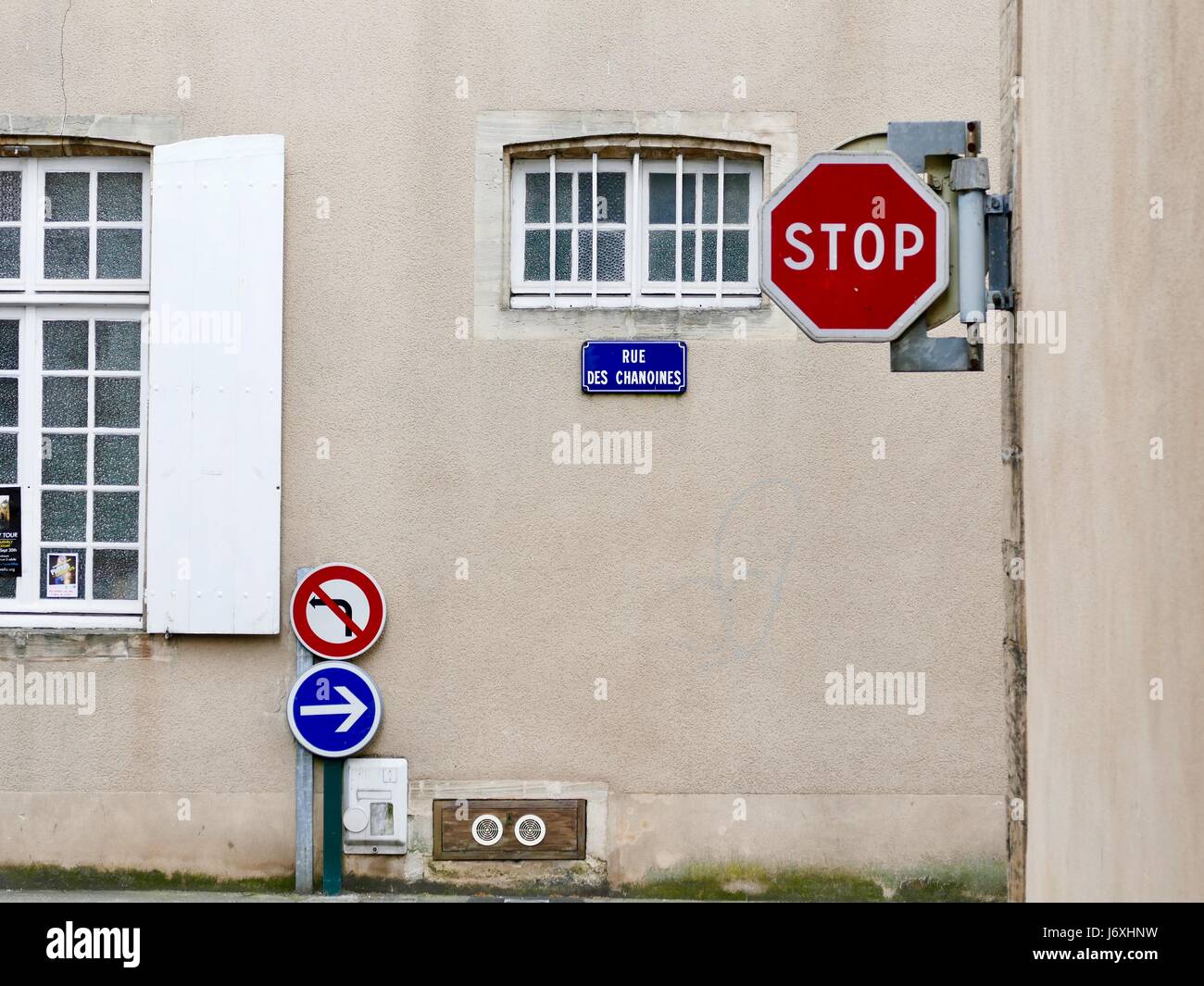 Des signes de Bayeux - Arrêter, pas de virage à gauche, aller à droite - contre un bâtiment en pierre blanche avec des fenêtres en bois. Bayeux, Calvados, France Banque D'Images