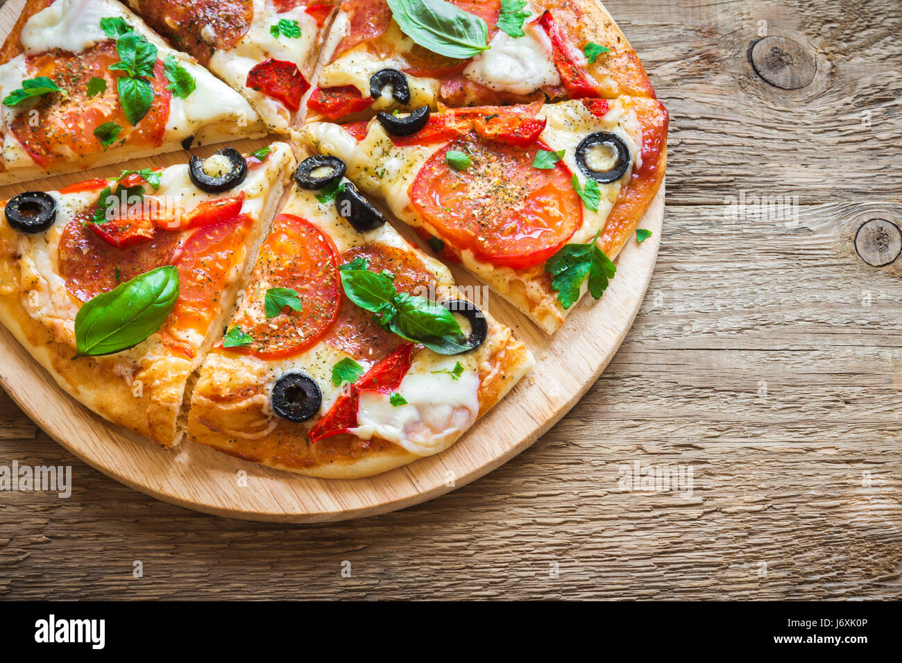 Pizza italienne avec tomates, olives noires, de salami et de fromage mozzarella close up. Des pizzas fraîches. Banque D'Images
