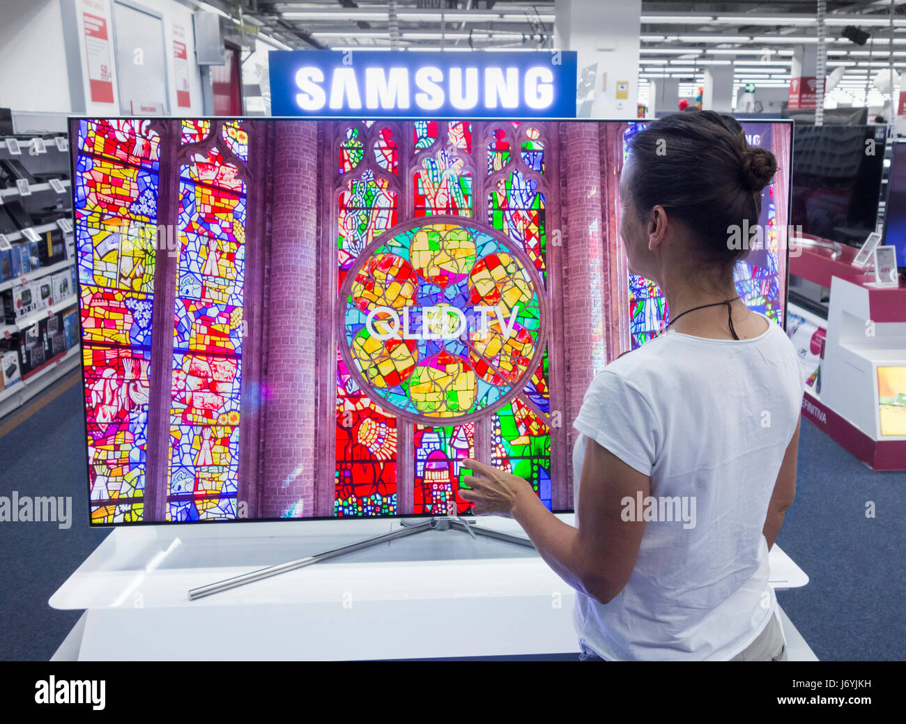 Woman looking at Samsung QLED TV en magasin électrique. Banque D'Images