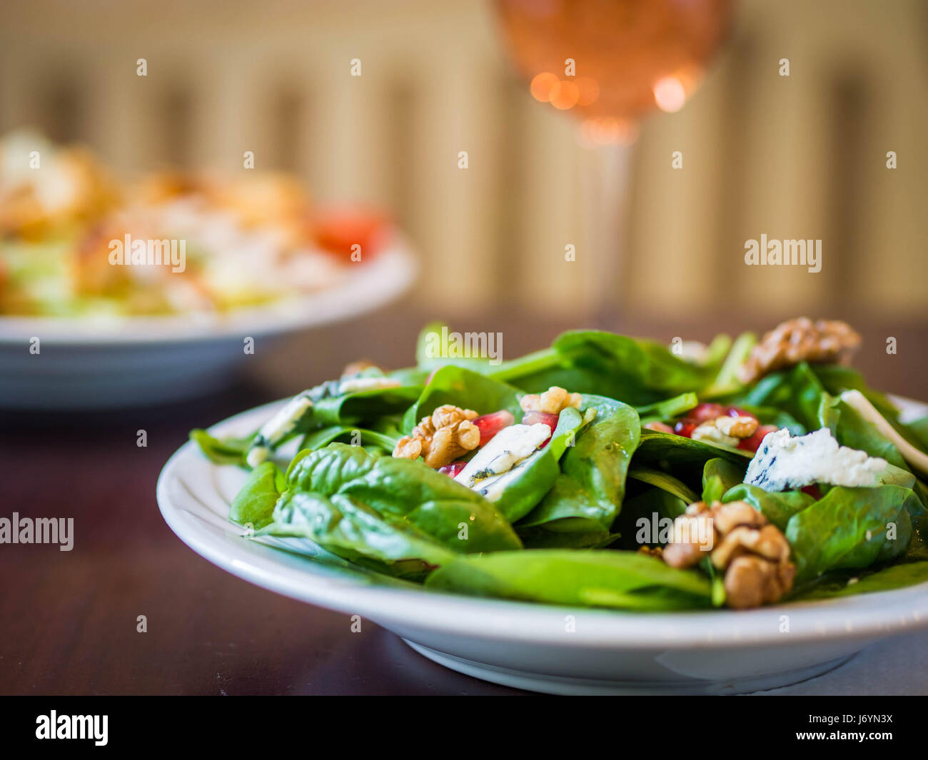 Salade d'épinards et fromage bleu avec un verre de vin rose Banque D'Images