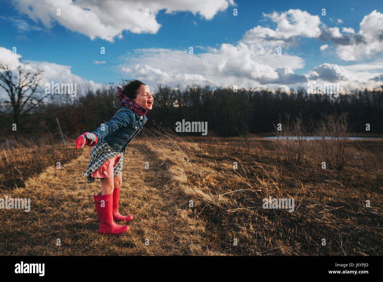 Girl with arms outstretched crier dans le vent Banque D'Images