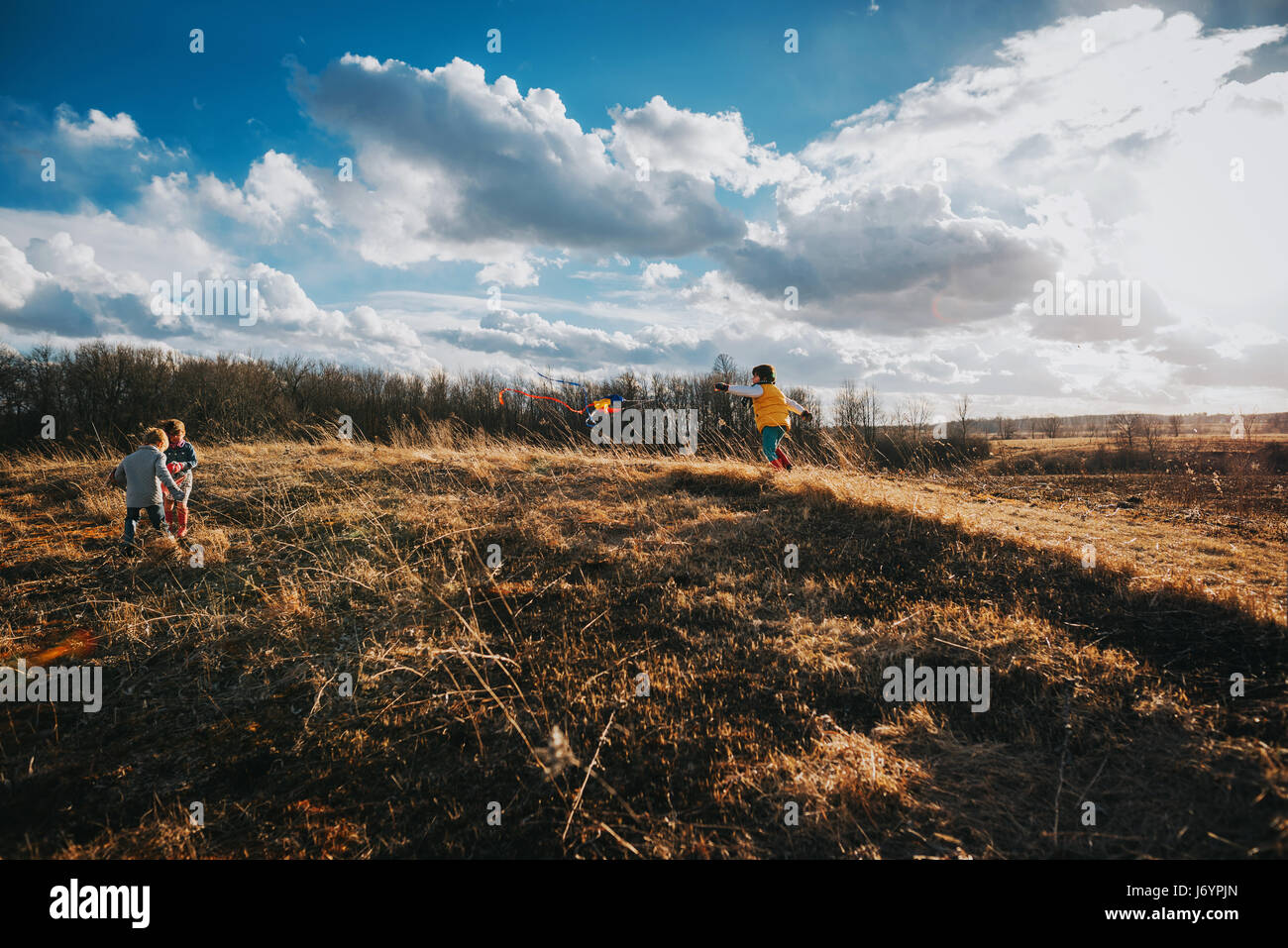 Trois enfants debout sur la colline parlementaire en jouant avec un cerf-volant Banque D'Images