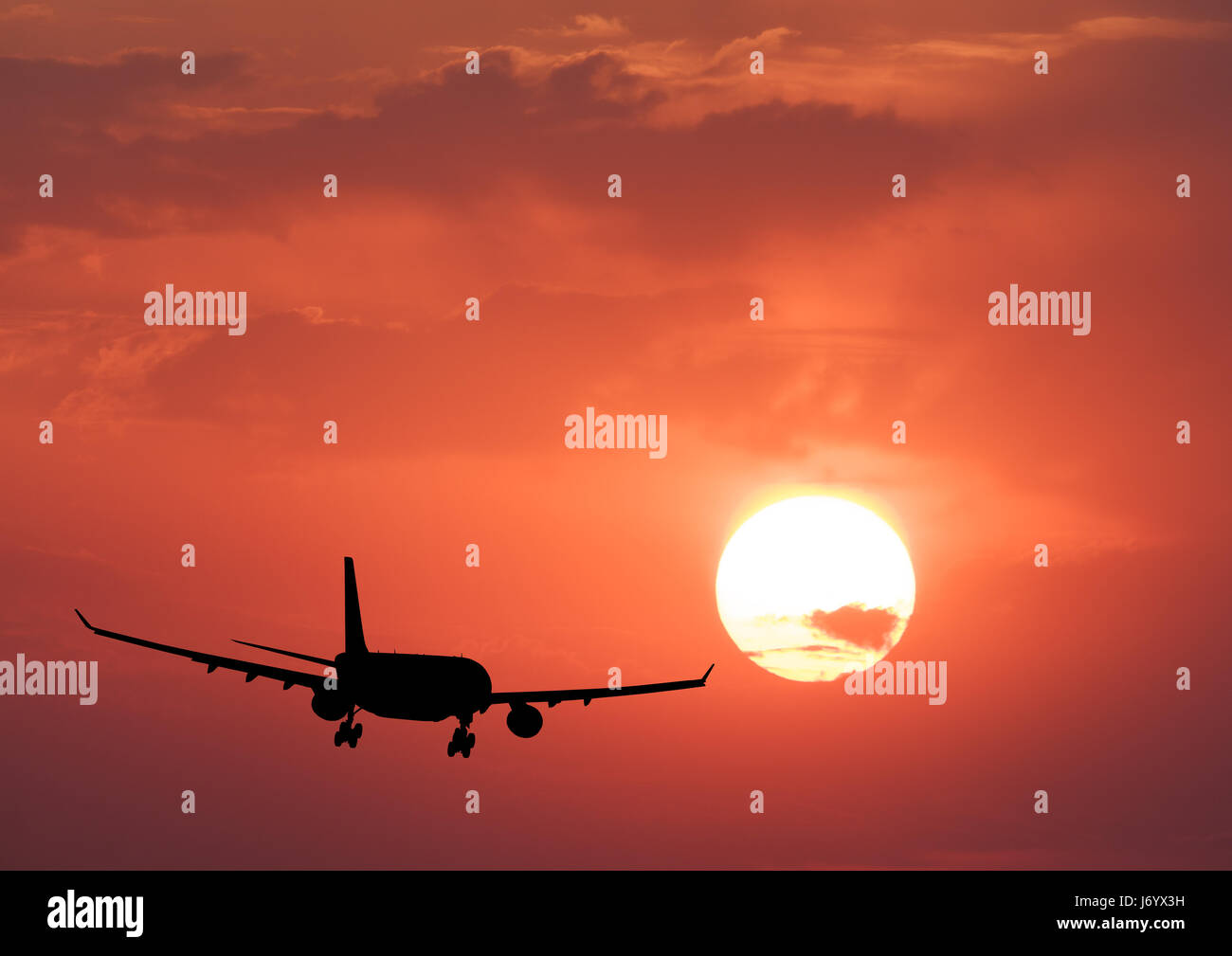 Silhouette d'un avion et ciel coloré avec soleil. Paysage avec avion passager vole dans le ciel avec les nuages orange au coucher du soleil. Zone de déplacement Banque D'Images