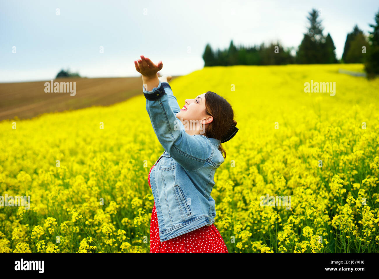 Une jeune femme en champ de colza. Banque D'Images