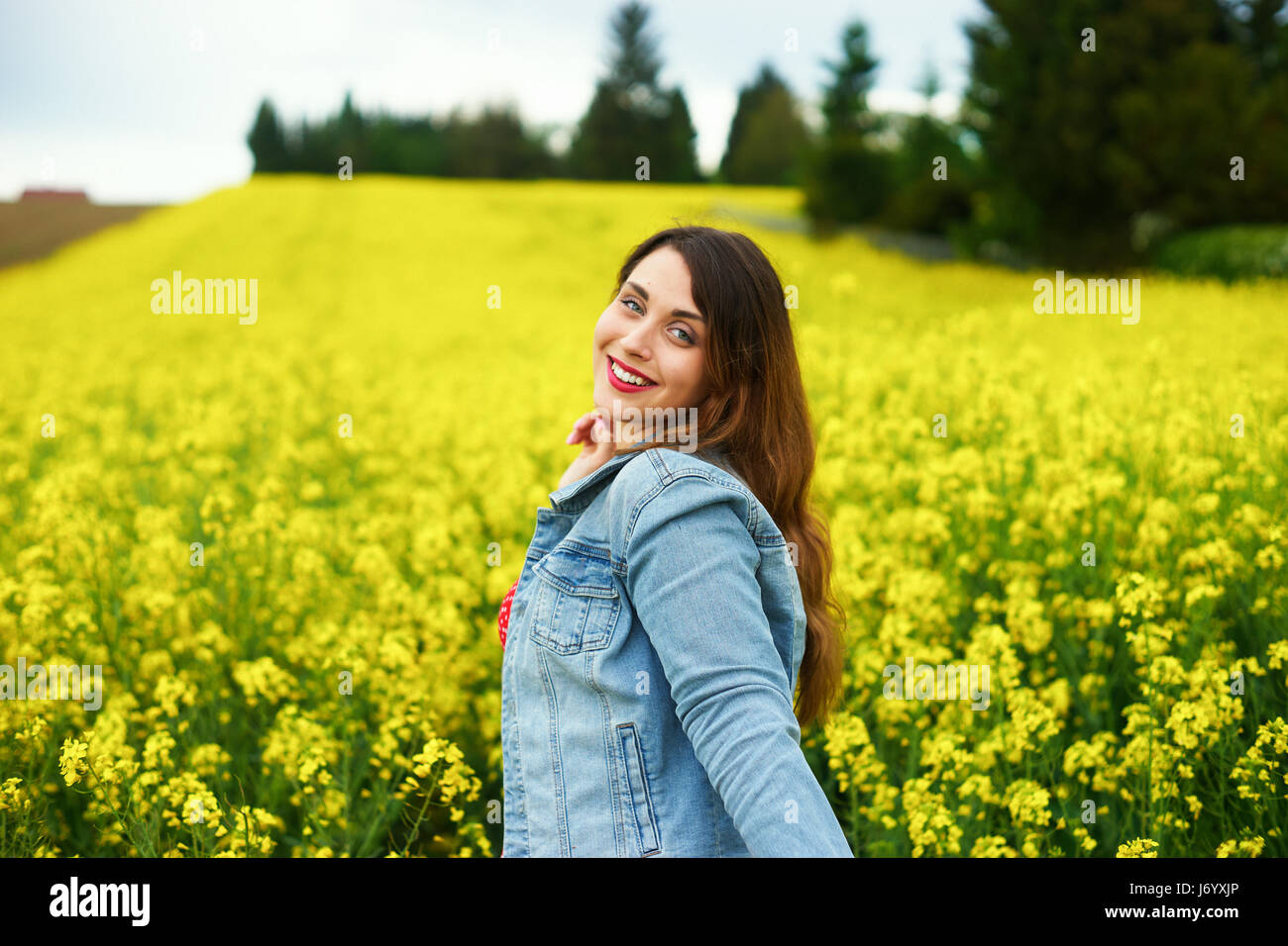 Une jeune femme de race blanche dans le champ de colza Banque D'Images