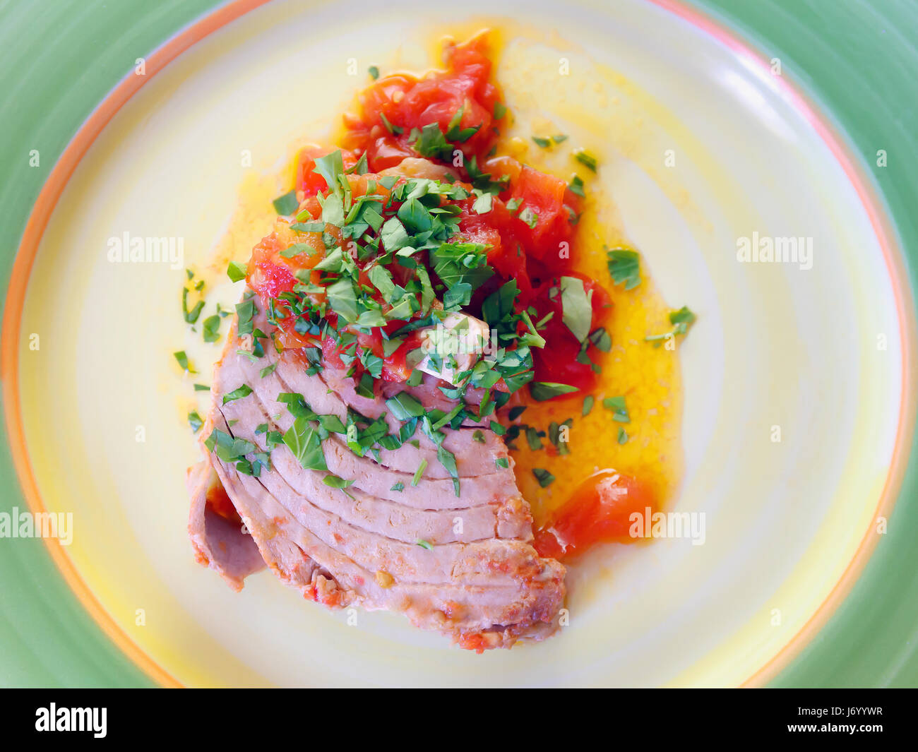 Filet de thon cuit dans la poêle avec l'huile, la tomate et le persil. Prêt à manger Banque D'Images