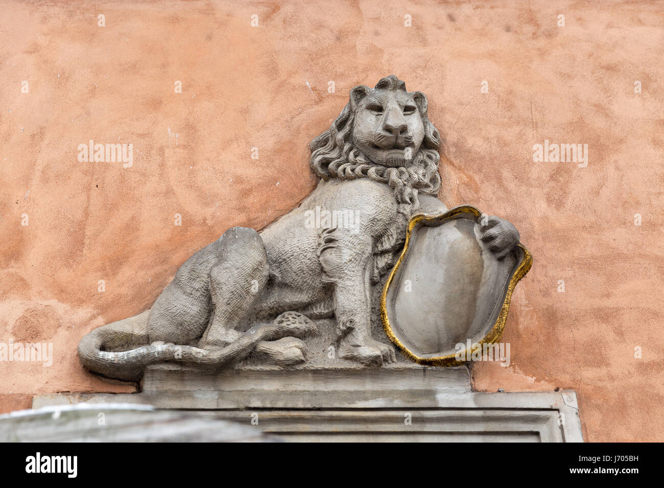 Bas-relief d'un lion avec un bouclier sur le mur du bâtiment à Varsovie, Pologne. Banque D'Images