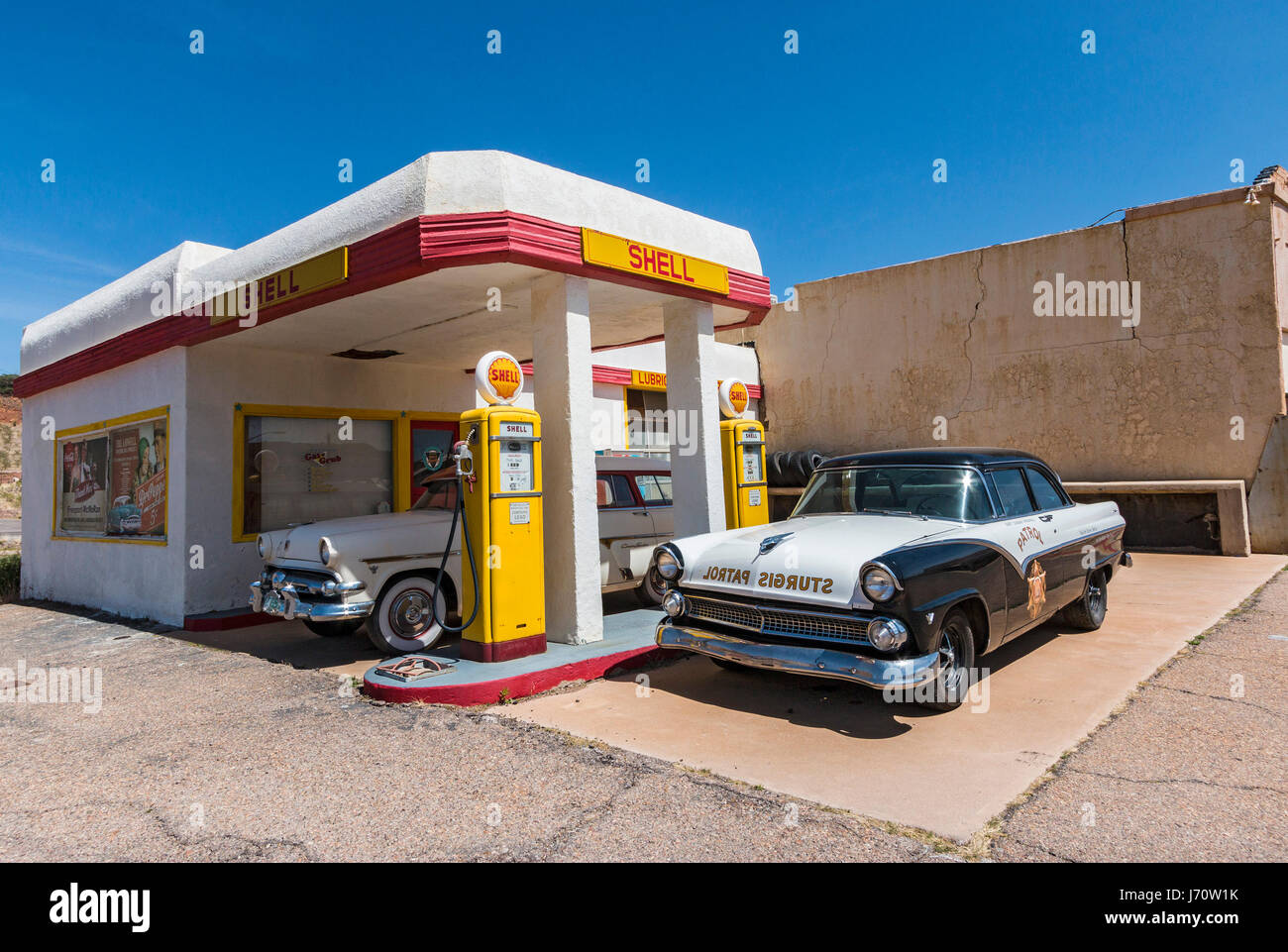 Vintage gas station complète avec de vieilles voitures, des pompes et de l'ads, à la périphérie