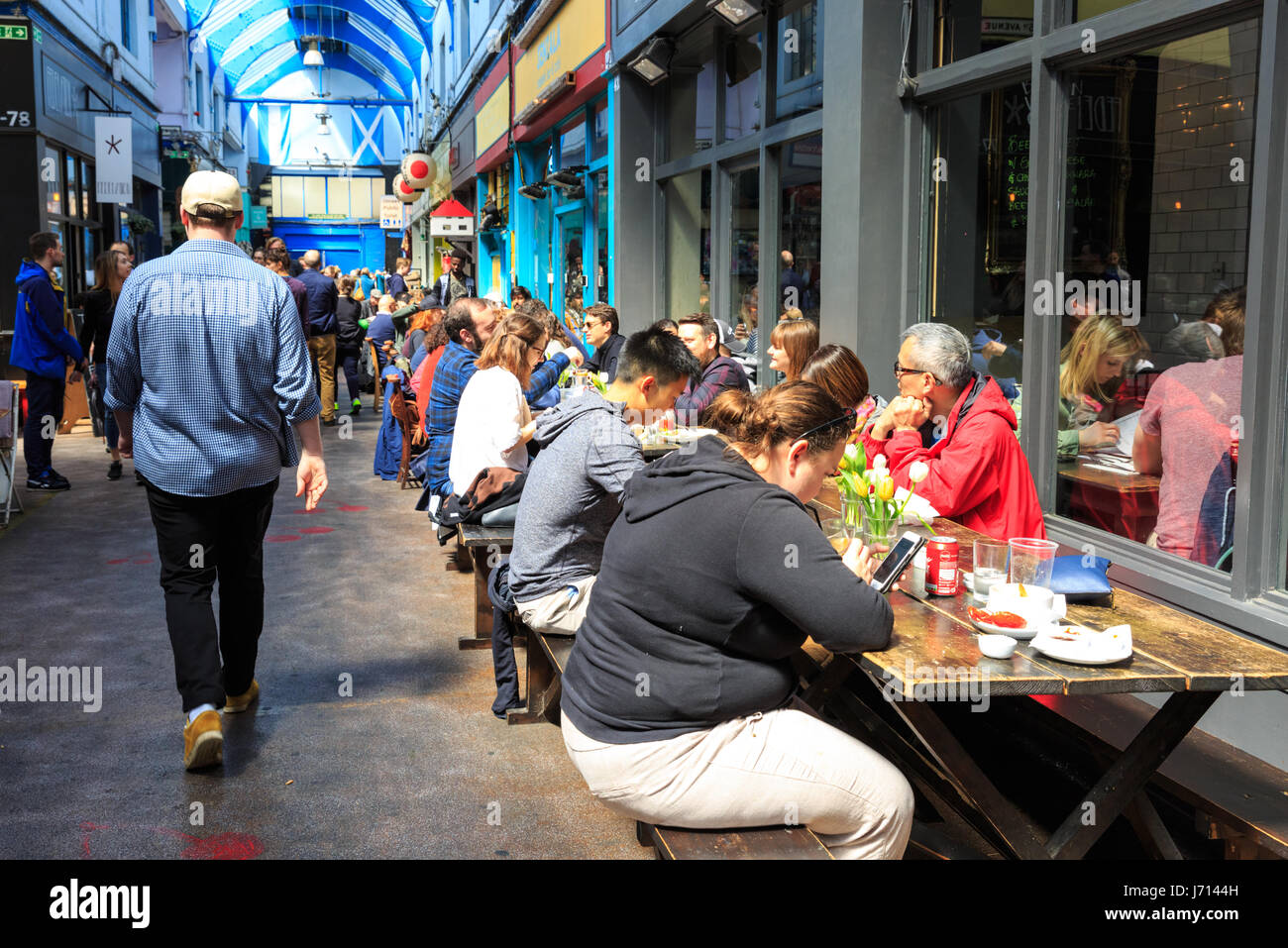 Les gens s'assoient dans les restaurants et bars à Brixton Village marché couvert, Brixton, London, UK Banque D'Images