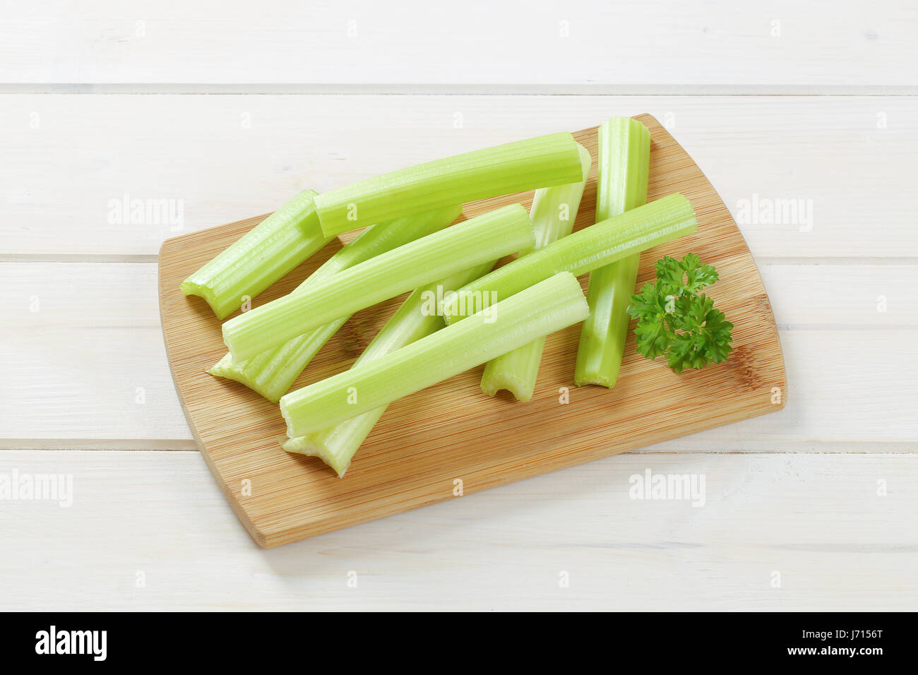 Tiges de céleri vert sur la planche à découper en bois Banque D'Images