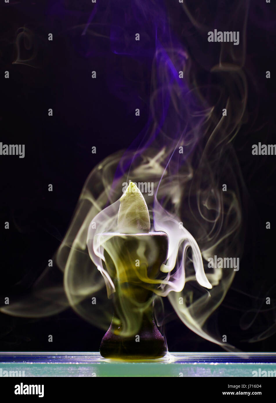 Cône aromatiques dans un couvant stand et émet de la fumée en céramique de différentes couleurs et de l'intensité Banque D'Images