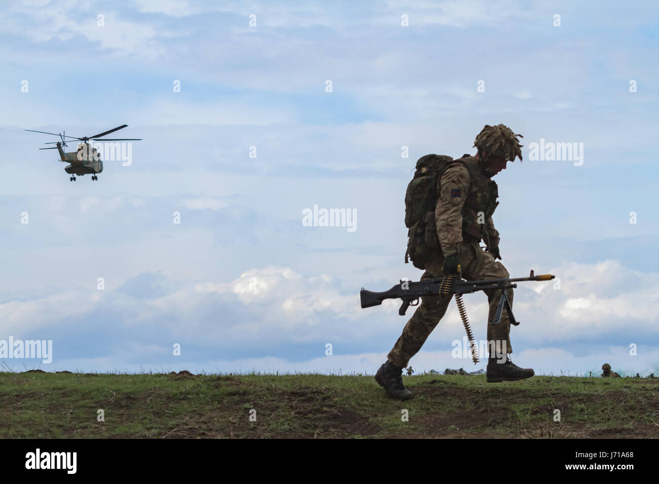 Les soldats britanniques se sont emportés devant un nouveau poste tout en étant défendus par un tanks roumain et un hélicoptère d'attaque lors de l'exercice militaire de l'OTAN « Wind Spring -15 » au stand de tir de Smardan Banque D'Images