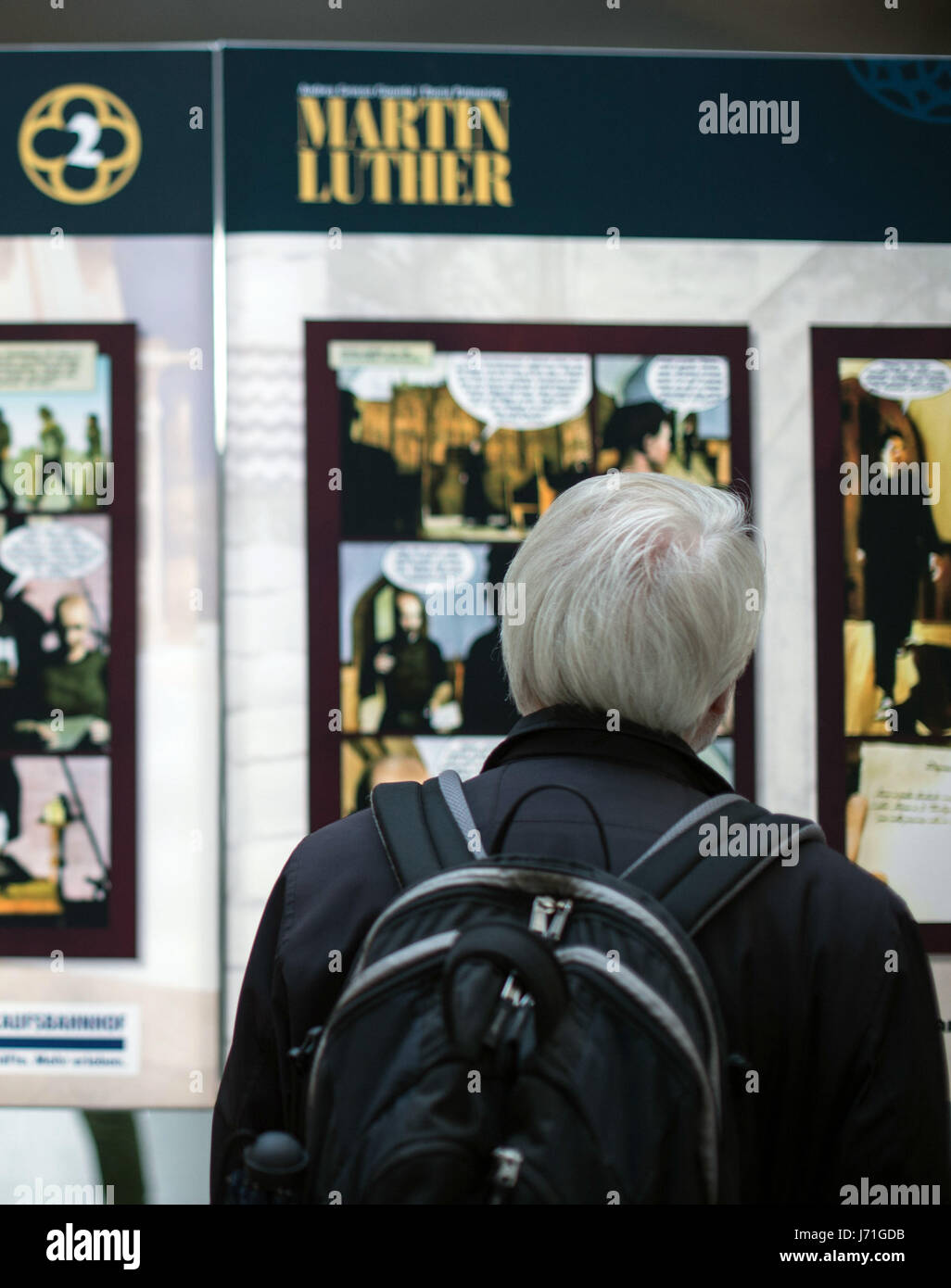 Berlin, Allemagne. 22 mai, 2017. Un voyageur se lit une bande dessinée-style histoire de la réforme, partie de la Luther exposition à la Hauptbahnhof (gare principale) à Berlin, Allemagne, 22 mai 2017. Luther l'exposition est présentée du 22 au 27 mai 2017. Photo : Lino Mirgeler/dpa/Alamy Live News Banque D'Images