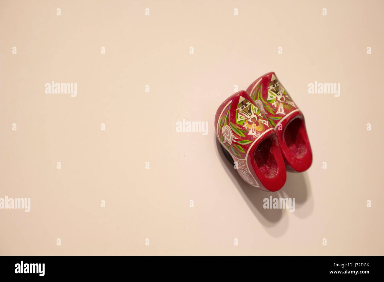 Vue rapprochée de l'aimant (bois isolé en forme de souvenir) Dutch slipper sur fond beige. Floral - fleurs sur elle. Banque D'Images