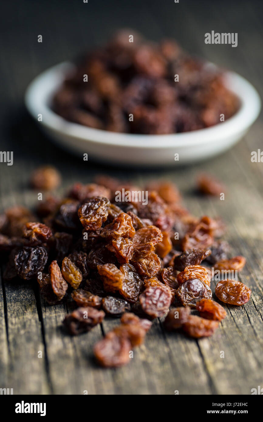 Raisins secs doux sur la vieille table en bois. Banque D'Images
