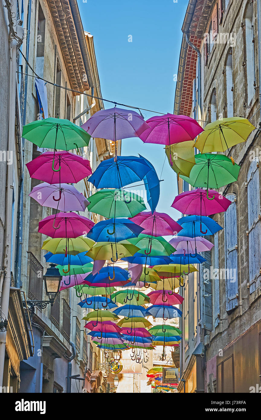 La pendaison parasols colorés entre les bâtiments au-dessus d'une rue dans la vieille ville à Béziers, France Banque D'Images