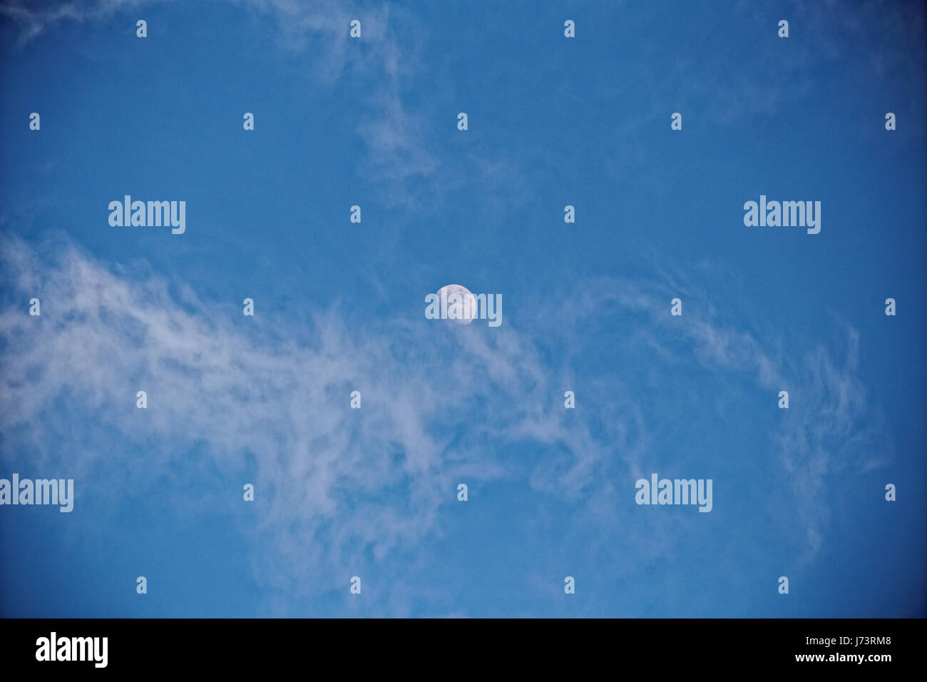 Lune dans journée ciel bleu blanc cirrus et filandreuse Banque D'Images