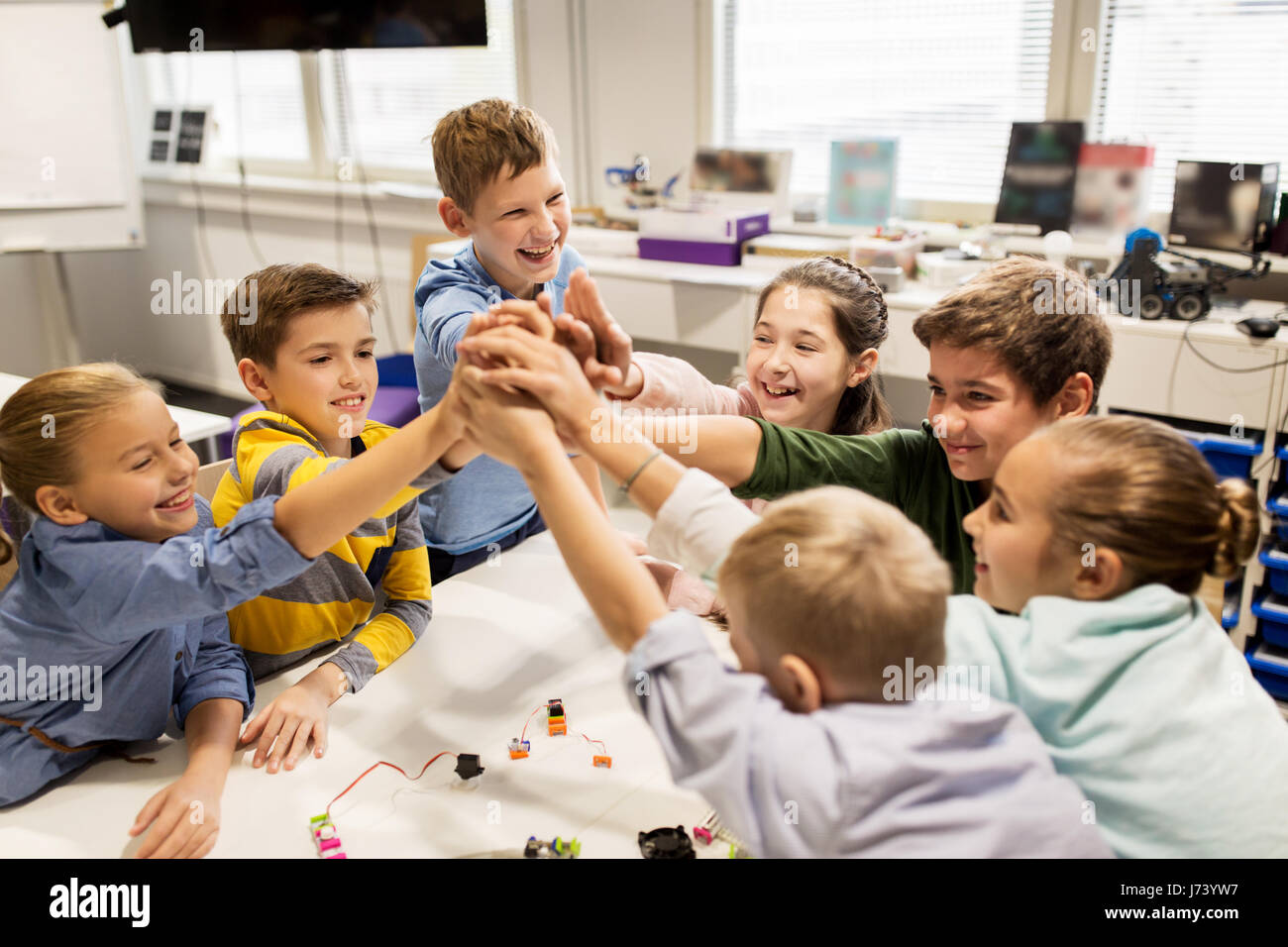 Des enfants heureux à l'école de robotique high five Banque D'Images