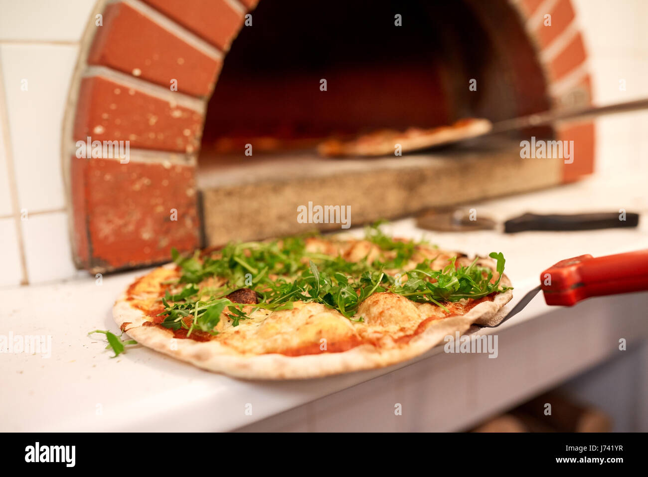 Sur peel pizza cuite au four pizzeria Banque D'Images Sur peel pizza cuite au four pizzeria Banque D'Images