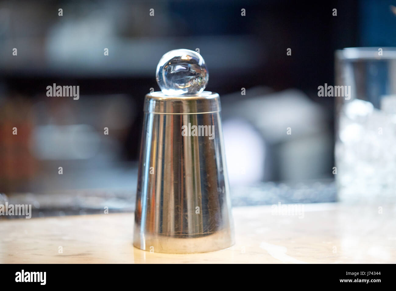Boule de glace à la main sur le dessus de shaker à bar Banque D'Images