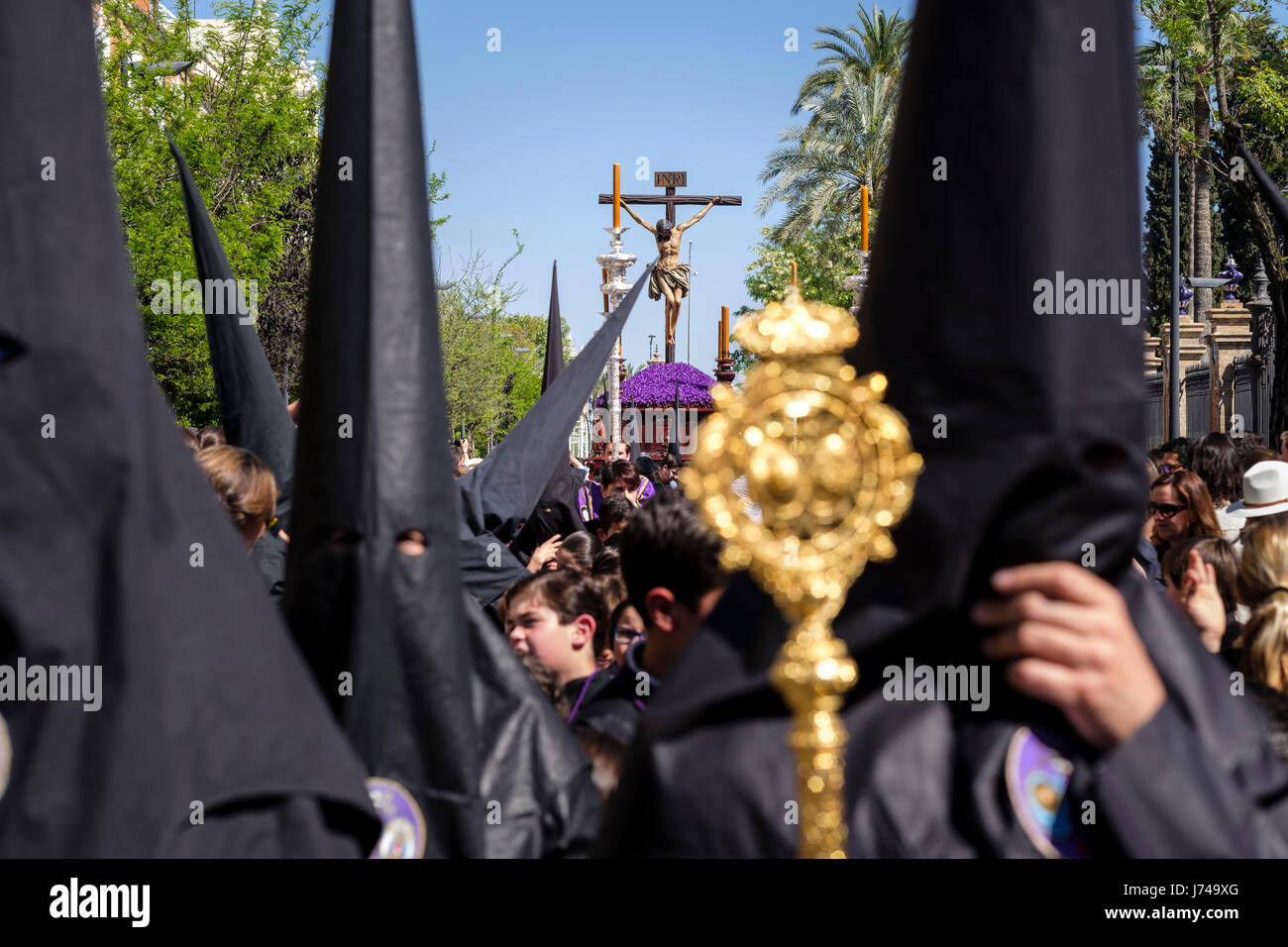 Pendant la semaine de Pâques, les processions avec l'image de Christ et de la vierge Marie parade autour de Séville. Monaguillos prêtre, la police et les pénitents mars Banque D'Images