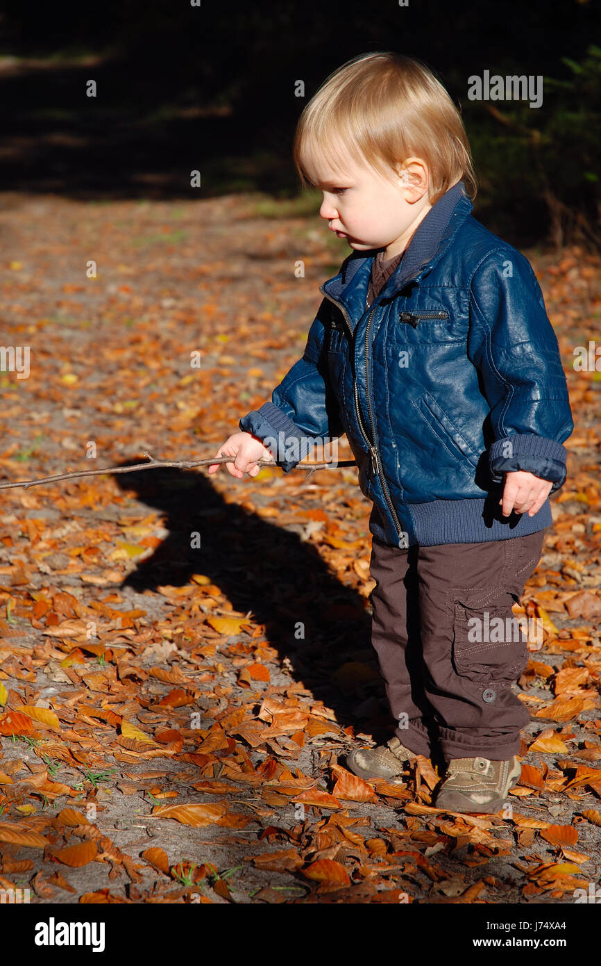 Jeune enfant plus jeune blonde feuilles forêt nature feuillage automne coloré d'automne Banque D'Images