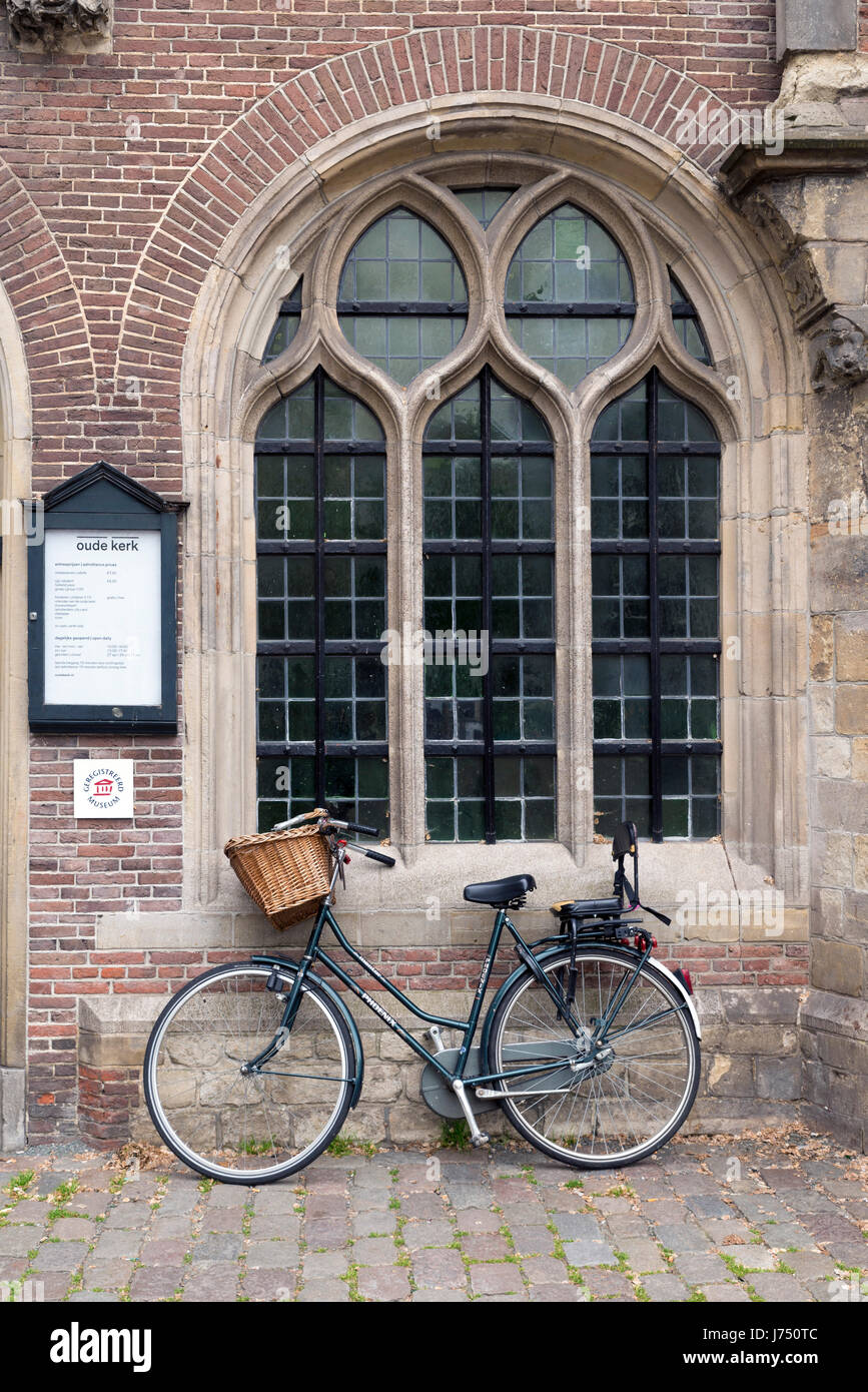 AMSTERDAM, Pays-Bas - 16 mai, 2017 : Une bicyclette appuyée sur la fenêtre de l'Oude Kerk (vieille église) dans le centre d'Amsterdam Banque D'Images