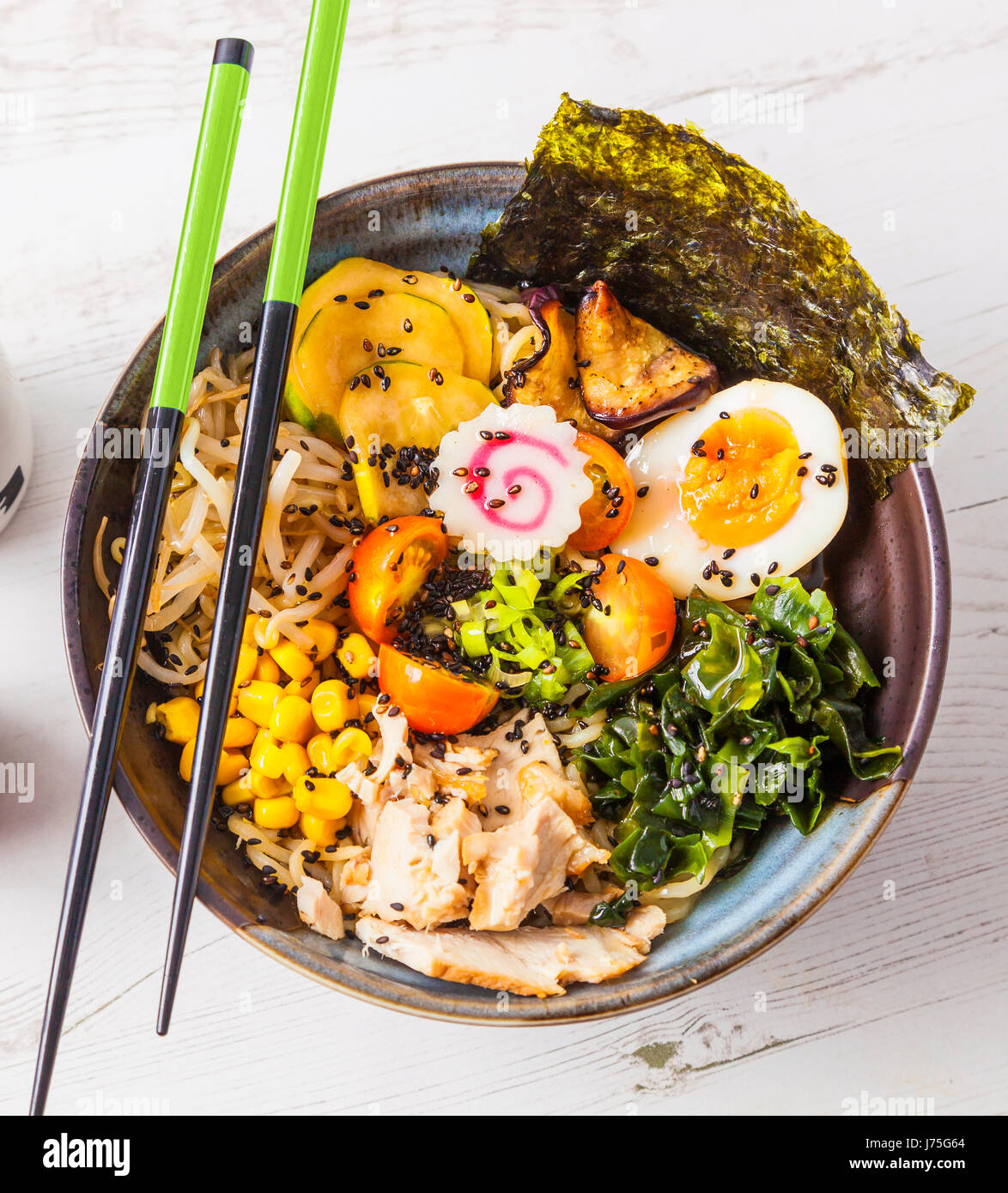 Le miso Ramen nouilles asiatiques avec de la viande et d'oeufs dans un bol blanc sur fond de bois. Banque D'Images