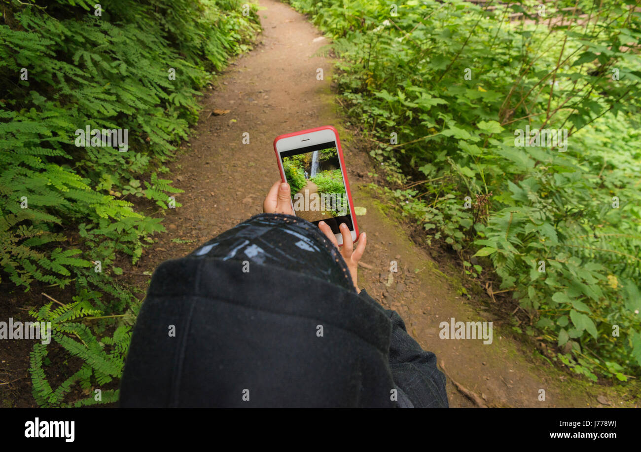 Portrait of boy photographier par téléphone mobile en se tenant sur le trail Banque D'Images