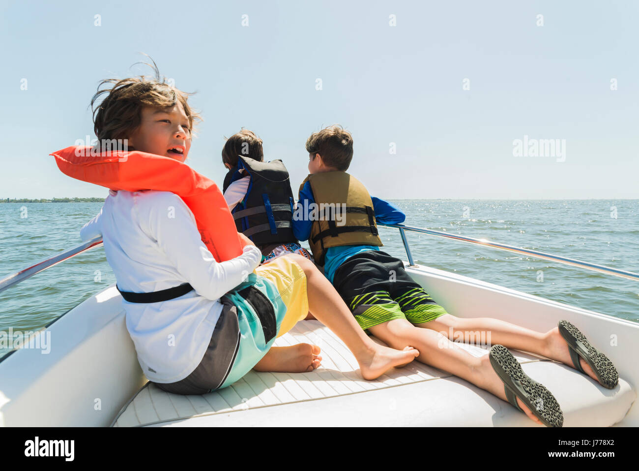 Frères portant des gilets de voyager en bateau contre un ciel clair au cours de journée ensoleillée Banque D'Images