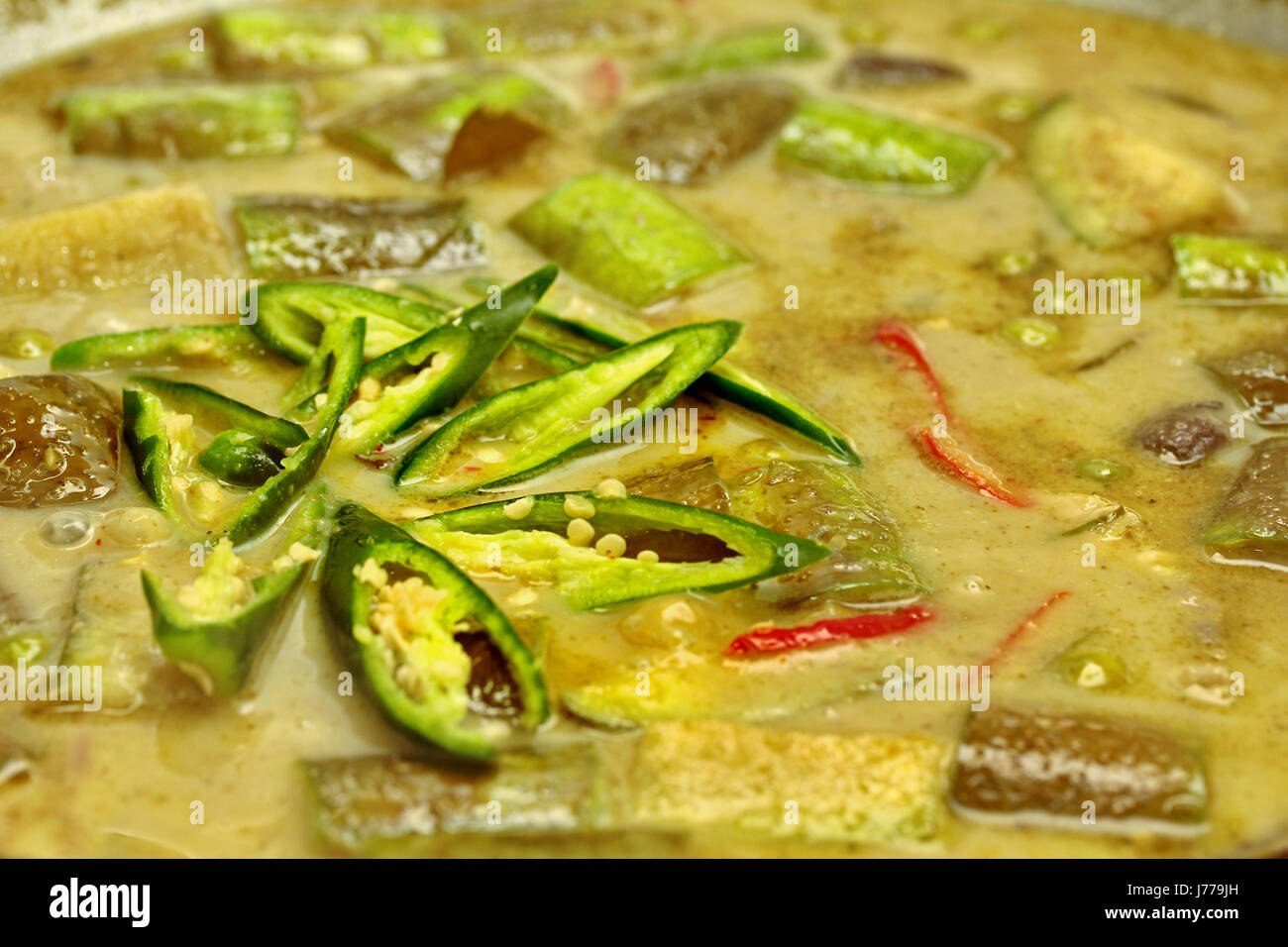 La cuisine du poulet au curry vert au lait de coco avec l'aubergine dans la poêle. Banque D'Images