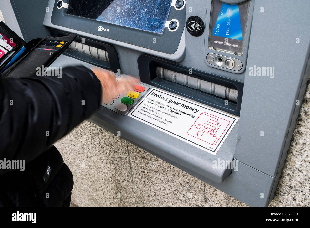 Un client en utilisant un guichet automatique Banque D'Images