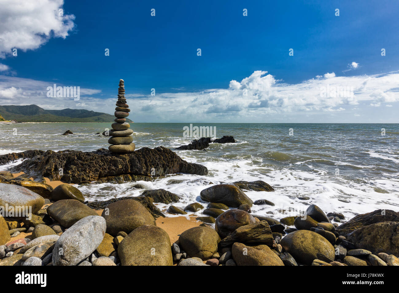 L'équilibrage de rochers empilés sur la plage entre Cairns et Port Douglas, Queensland, Australie Banque D'Images