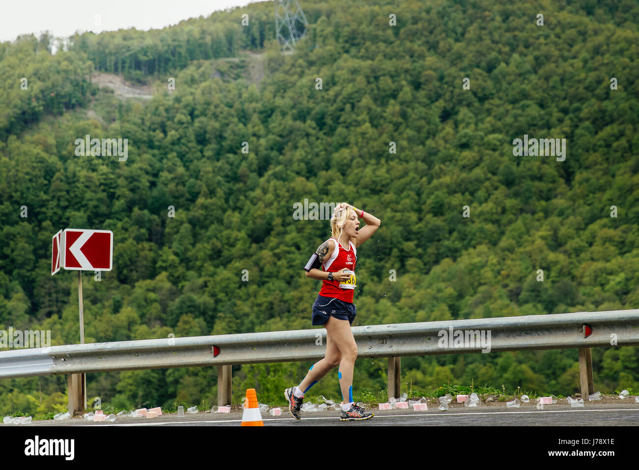 Rosa Khutor, Russie - Mai 7, 2017 : young woman runner sur point d'eau dans une éponge à la main avec de l'eau dans le ressort de la course marathon de montagne Banque D'Images