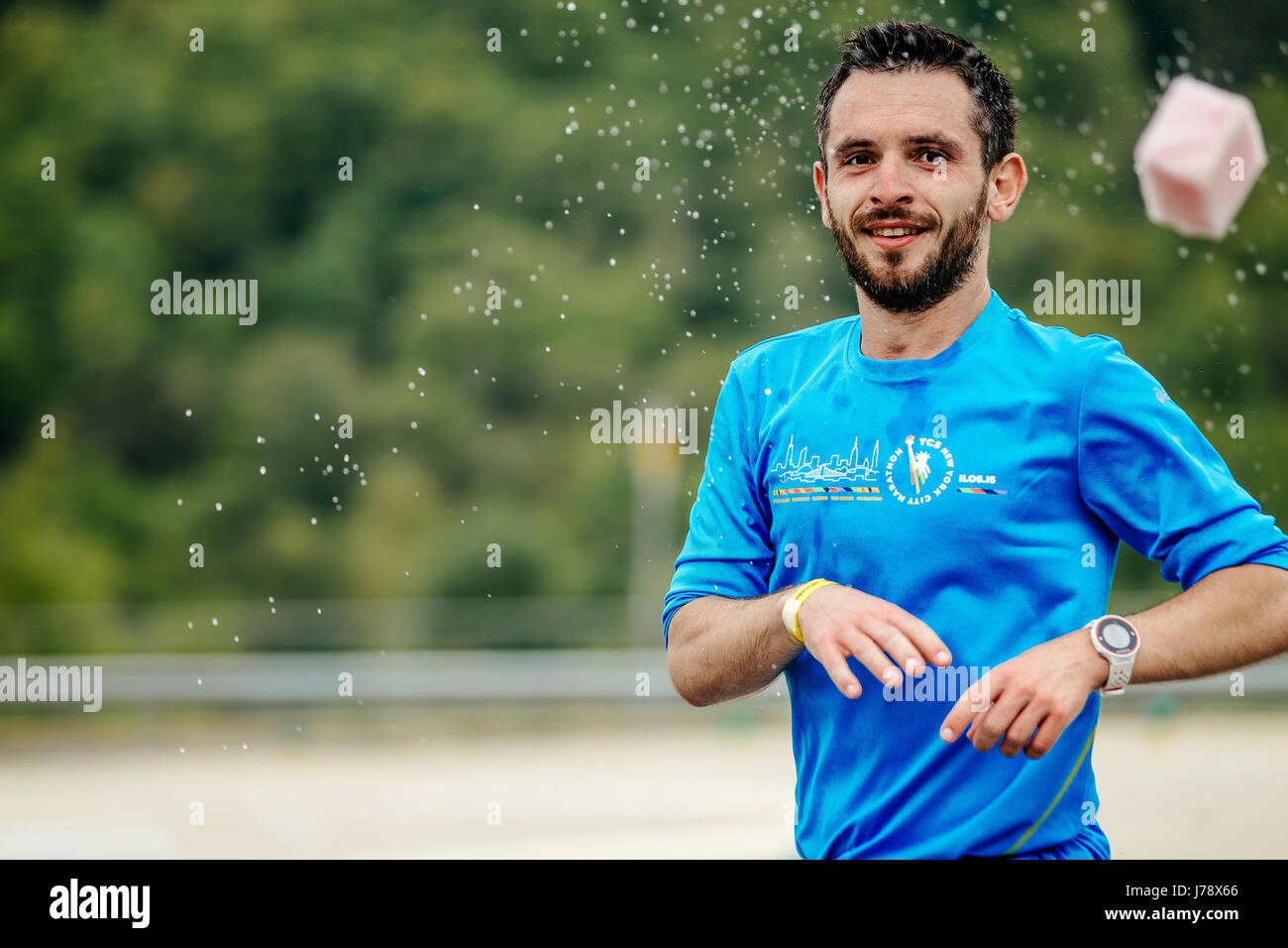 Homme runner sur point d'eau se jette dans l'eau éclaboussant éponge printemps course marathon de montagne Banque D'Images