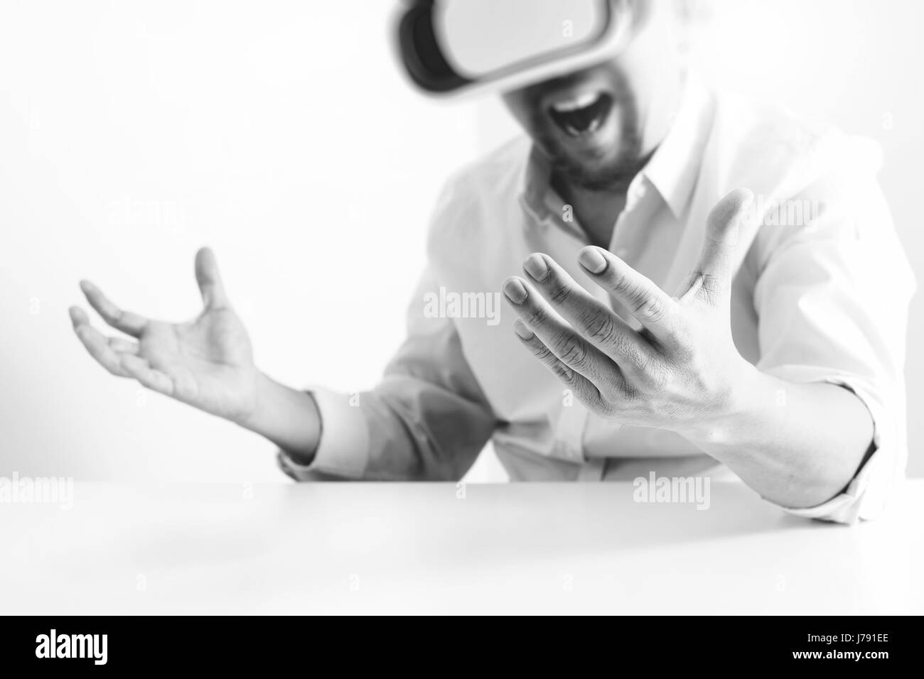 Businessman wearing lunettes de réalité virtuelle dans un bureau moderne avec l'aide du Smartphone avec casque VR noir et blanc Banque D'Images