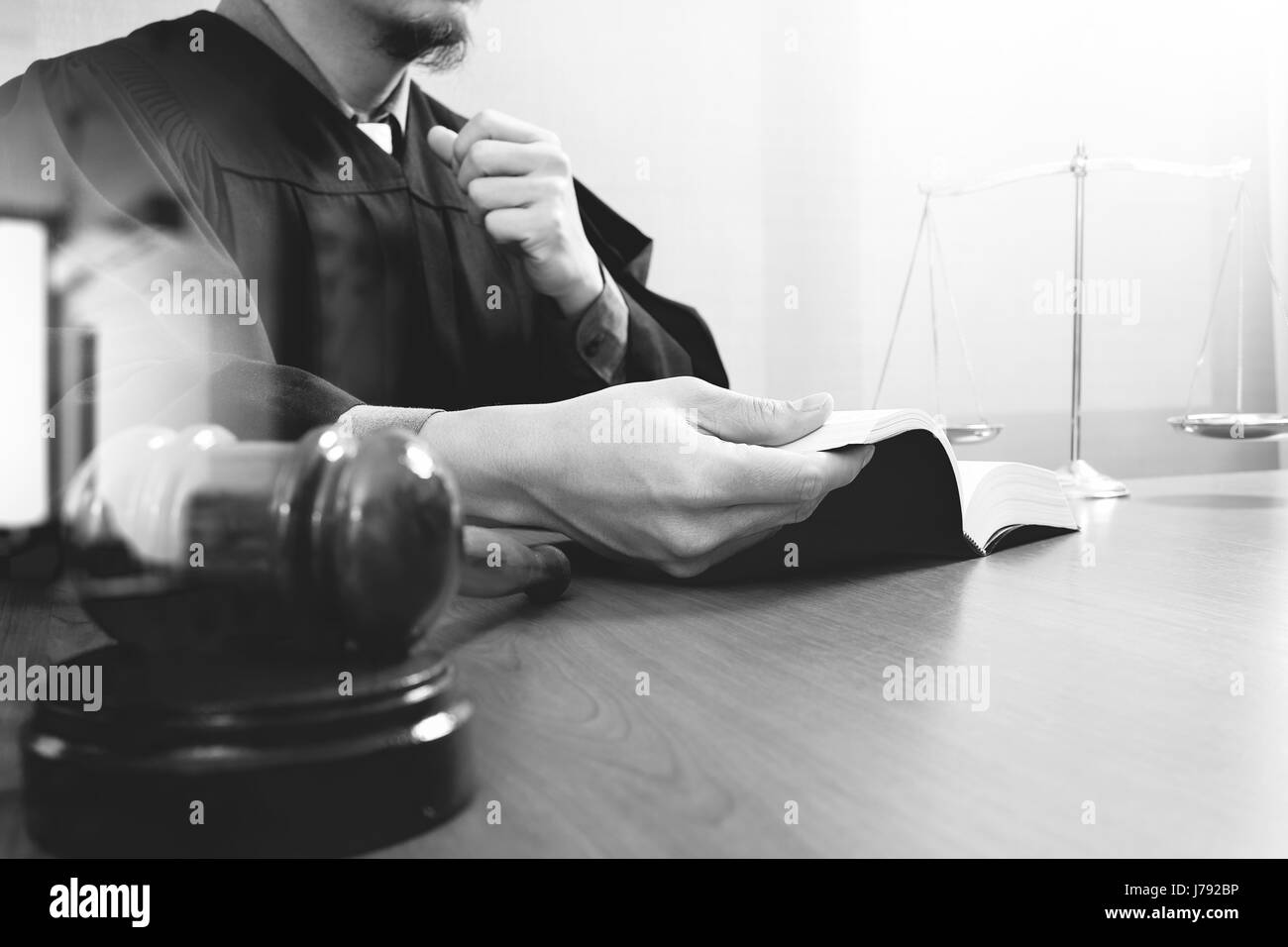 La justice et du droit concept.Homme juge dans une salle d'audience avec le maillet, le livre saint de l'ouverture et l'ordinateur tablette numérique avec échelle en laiton sur bois tableau noir,un Banque D'Images