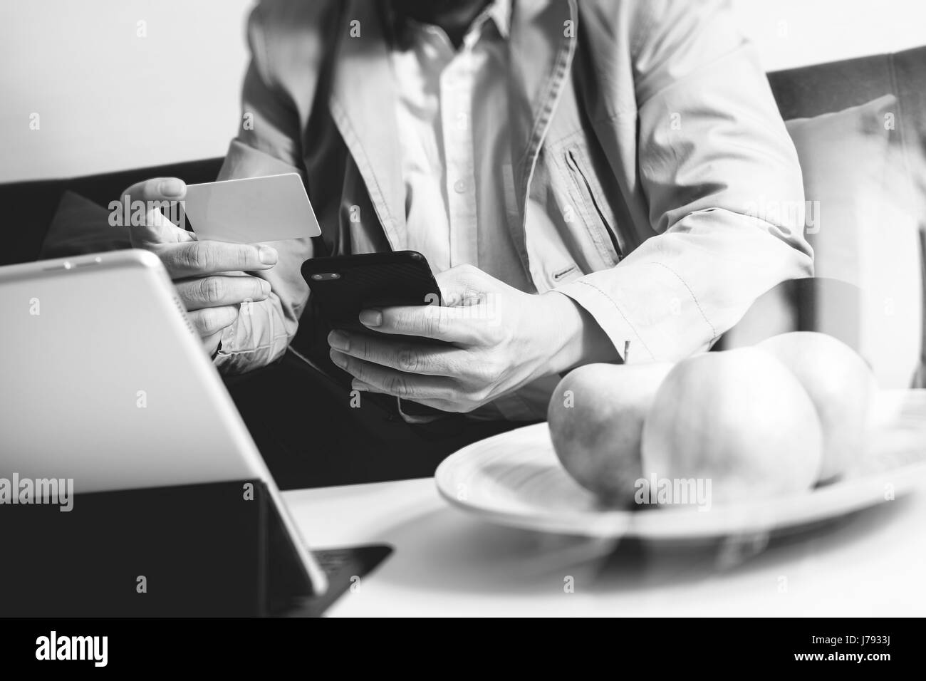 Hipster la main à l'aide de Smart Phone, tablette numérique, clavier d'holding cradit paiements par carte bancaire les entreprises en ligne, sitting on sofa in living room,travailler à la maison Banque D'Images
