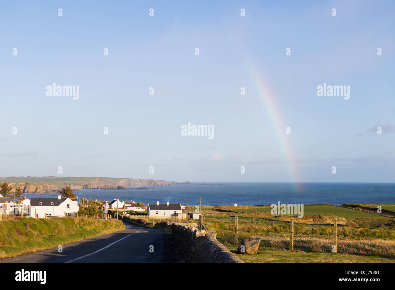 Un arc-en-ciel en milieu rural campagne irlandaise se terminant dans la mer d'Irlande Banque D'Images